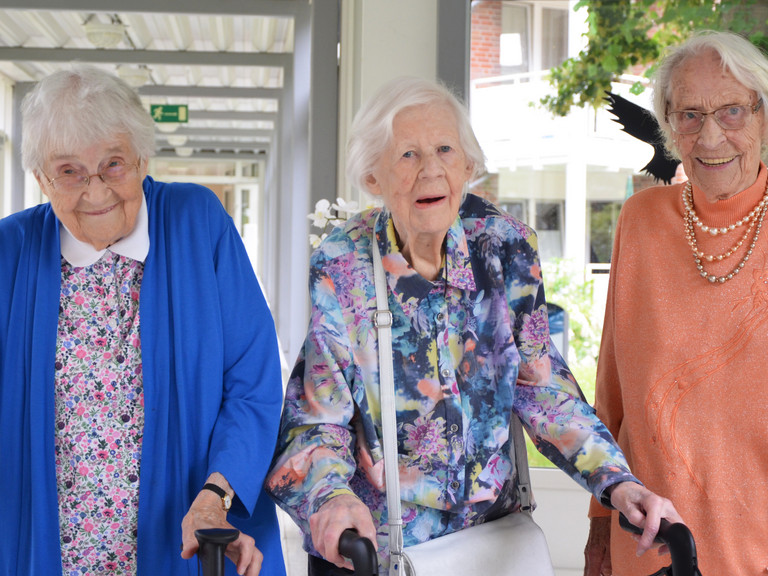 Nora Matthaei (101 Jahre), Hannelore Sieg (99 Jahre) und Else Pahling (101 Jahre) lächeln bei einem gemeinsamen Gruppenfoto vor der Residenz am Wiesenkamp in Hamburg-Volksdorf zu ihren Geburtstagen im Juli in die Kamera