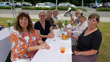 Sieben Besucherinnen sitzen an einem mit weißem Stoff überzogenen Tisch mit Getränken, Essen und Blumenschmuck und blicken in die Kamera beim Sommerfest 2026 auf dem Gesundheitscampus Volksdorf des Evangelischen Amalie Sieveking Krankenhauses, der Residenz am Wiesenkamp, des Feierabendhauses Volksdorf und der Albertinen Kindertagesstätte Volksdorf. Sieben Besucherinnen sitzen an einem mit weißem Stoff überzogenen Tisch mit Getränken, Essen und Blumenschmuck und blicken in die Kamera beim Sommerfest 2026 auf dem Gesundheitscampus Volksdorf des Evangelischen Amalie Sieveking Krankenhauses, der Residenz am Wiesenkamp, des Feierabendhauses Volksdorf und der Albertinen Kindertagesstätte Volksdorf.