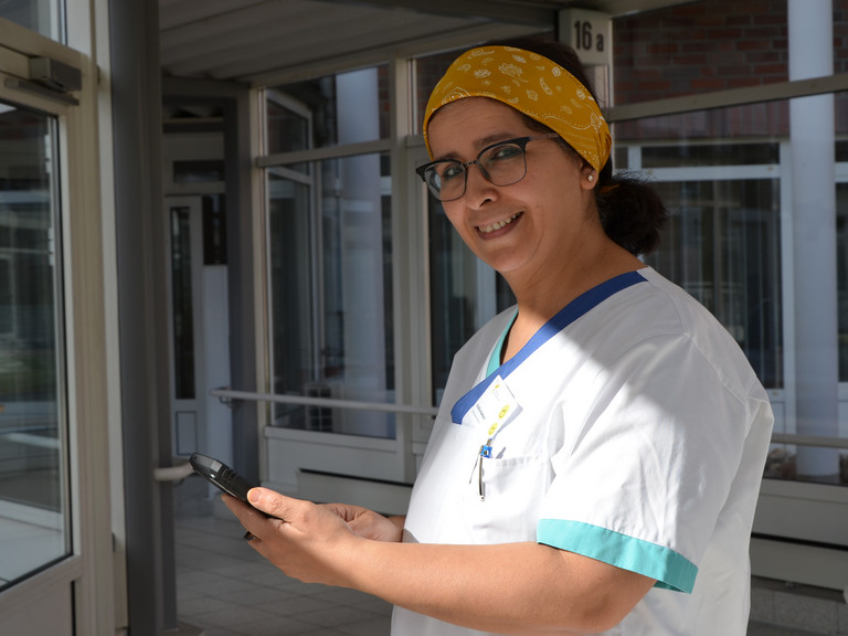 Krankenpflegerin hält Handy in der Hand in der Residenz am Wiesenkamp in Hamburg Volksdorf