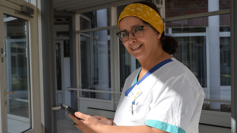 Krankenpflegerin hält Handy in der Hand in der Residenz am Wiesenkamp in Hamburg Volksdorf Krankenpflegerin hält Handy in der Hand in der Residenz am Wiesenkamp in Hamburg Volksdorf