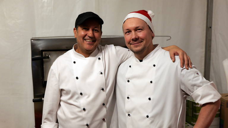 Zwei Köche der Albertinen Services Hamburg in weißen Kochschürzen blicken fröhlich in die Kamera bei der Weihnachtsfeier 2025 von Amalie Sieveking Krankenhaus, Residenz am Wiesenkamp, Feierabendhaus Volksdorf und Albertinen Kindertagesstätte Volksdorf auf dem Gesundheitscampus Volksdorf in Hamburg Zwei Köche der Albertinen Services Hamburg in weißen Kochschürzen blicken fröhlich in die Kamera bei der Weihnachtsfeier 2025 von Amalie Sieveking Krankenhaus, Residenz am Wiesenkamp, Feierabendhaus Volksdorf und Albertinen Kindertagesstätte Volksdorf auf dem Gesundheitscampus Volksdorf in Hamburg
