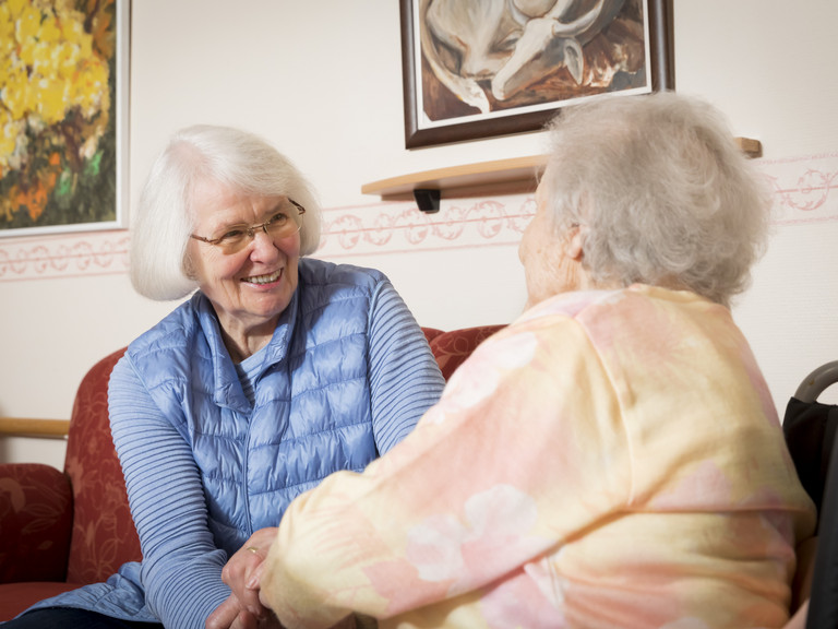 Zwei Seniorinnen unterhalten sich angeregt, Unterstützung und Hilfe im Alltag im Seniorenheim, Rezeption Erreichbarkeit in der Seniorenresidenz, Hamburg-Volksdorf 