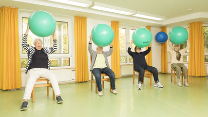 Vier Frauen machen Sportübungen mit einem Pezziball im Sitzen, was kann man in der Residenz am Wiesenkamp machen?, Freizeitprogramm, Sport für Seniorinnen und Senioren, Ausflüge, Unterhaltungsprogramm im Seniorenheim, Hamburg-Volksdorf