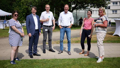 Dr. Thorsten Minuth, Konzerngeschäftsführer Immanuel Albertinen Diakonie, Krankenhaus-Geschäftsführer Andreas Schneider und Pflegedirektorin Maike Sellentin stehen mit mehreren Mitarbeitenden zusammen und blicken in die Kamera beim Sommerfest 2026 auf dem Gesundheitscampus Volksdorf des Evangelischen Amalie Sieveking Krankenhauses, der Residenz am Wiesenkamp, des Feierabendhauses Volksdorf und der Albertinen Kindertagesstätte Volksdorf. Dr. Thorsten Minuth, Konzerngeschäftsführer Immanuel Albertinen Diakonie, Krankenhaus-Geschäftsführer Andreas Schneider und Pflegedirektorin Maike Sellentin stehen mit mehreren Mitarbeitenden zusammen und blicken in die Kamera beim Sommerfest 2026 auf dem Gesundheitscampus Volksdorf des Evangelischen Amalie Sieveking Krankenhauses, der Residenz am Wiesenkamp, des Feierabendhauses Volksdorf und der Albertinen Kindertagesstätte Volksdorf.